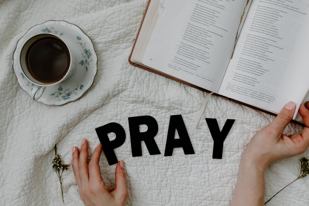 A Person Reading a Book Beside the Black Text and Coffee