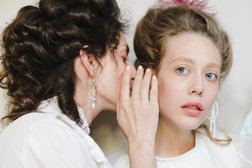 A Woman Whispering to the Ear of Another Woman